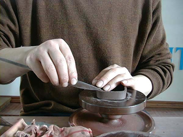 33、以修量切好之泥片為規範，將切好適當尺寸及厚度之泥片條，圈圍在前述之泥片外圍，使呈四方狀；再以旁皮刀以45度角同時切斷圈起後重疊之泥片條，後將多出之小殘片拿掉，再將45度角切剝面塗上稀泥，黏合、修整至完美順暢。