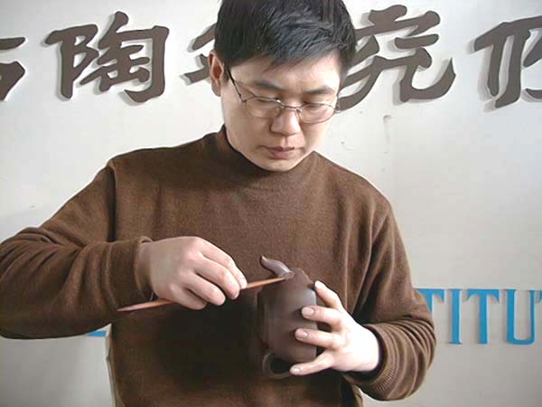 40、接好壺嘴壺把後，以劃子、小竹插等，各式各樣工具，修整或填補各角度之接合處，至線條流暢、無瑕、及自然始可。