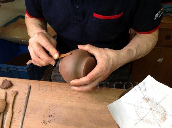 5、以制壶工具的“划子”挑出些许事先备好的“稀泥”，就依划好的记号线堆砌起浑角来了。